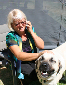 Barbara stroking her dog while talking on the phone to the builder.